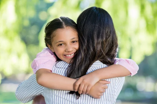 Girl embracing her mother in park — Stock Photo, Image