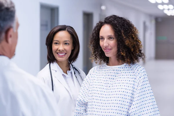 Gravid kvinna interagerar med läkare i korridor — Stockfoto