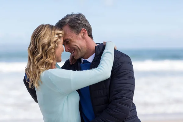 Ouder paar omhelzen elkaar op het strand — Stockfoto