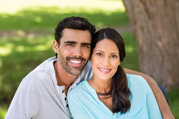 Portrait of couple sitting together in a park — Stock Photo, Image