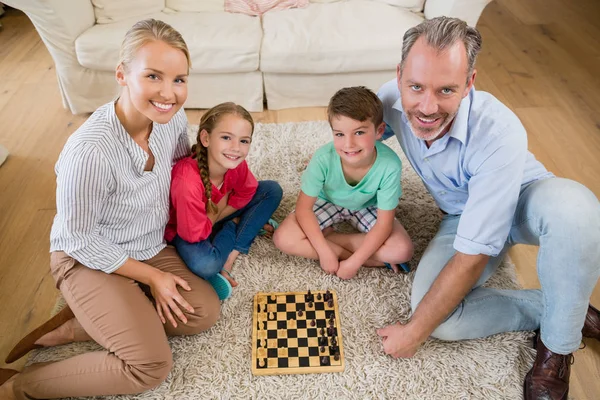 Familj spelar schack tillsammans hemma i vardagsrummet — Stockfoto