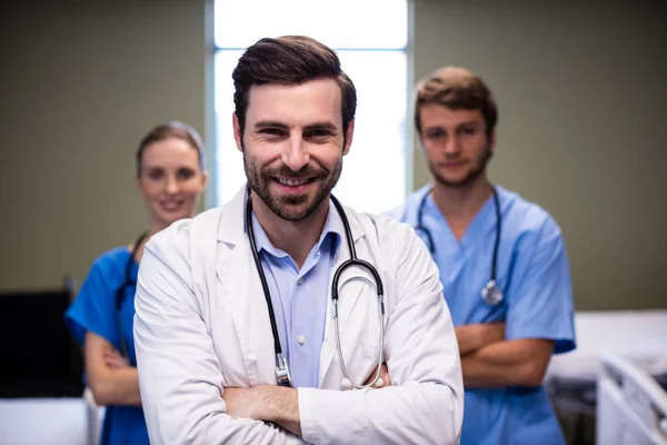 Porträtt av manliga läkare och hans kollega står med armarna korsade — Stockfoto