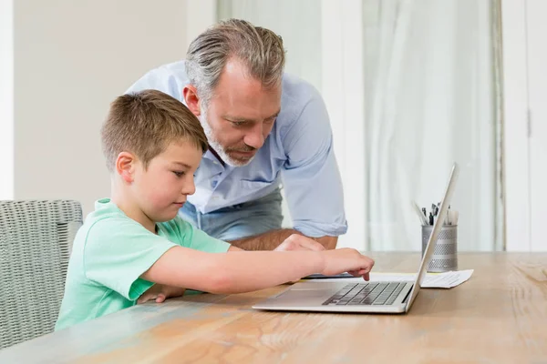 父亲和儿子在桌子上使用笔记本电脑 — 图库照片