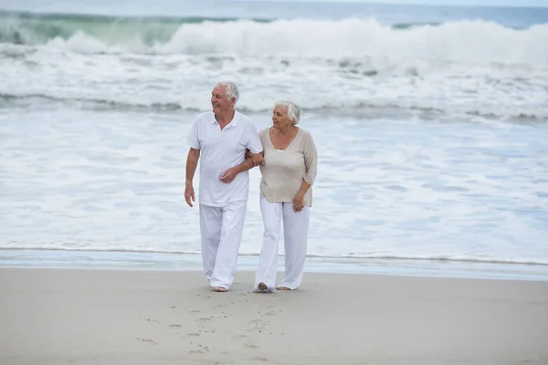 Senior paar lopen samen op het strand — Stockfoto