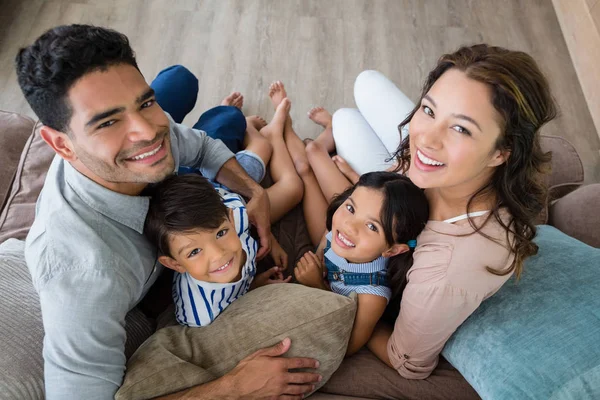 Portré a boldog szülőknek és gyerekeknek ül a nappaliban kanapé — Stock Fotó