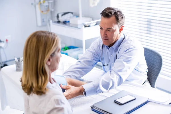 Dokter memeriksa tekanan darah pasien di klinik — Stok Foto