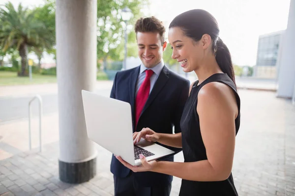 Homme d'affaires et collègue discutant sur ordinateur portable — Photo