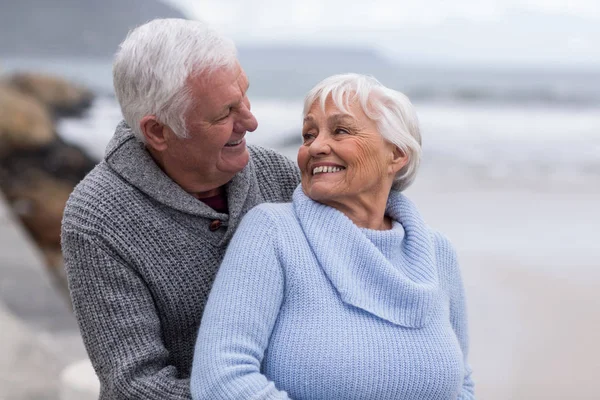 Senior paar omhelzen elkaar op het strand — Stockfoto