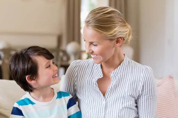 Sorridente madre che interagisce con il figlio in soggiorno — Foto Stock