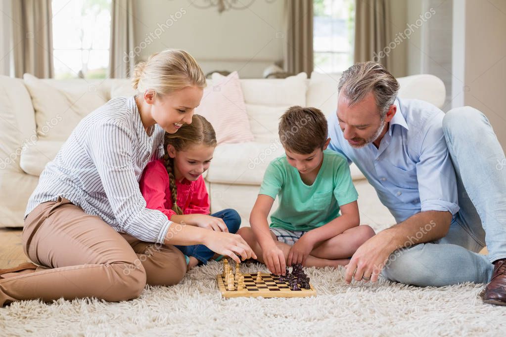 Familia jugando al ajedrez juntos en casa, en la sala de estar — Foto