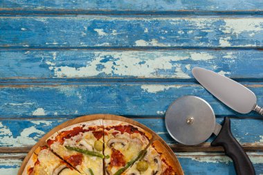 Italian pizza served on pizza tray with cutter and knife on wooden plank clipart