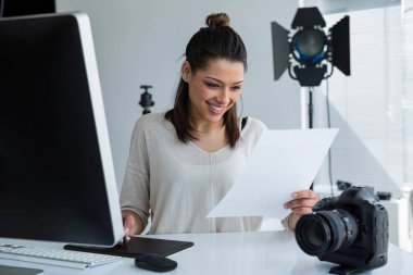 photographer using graphic tablet at desk clipart