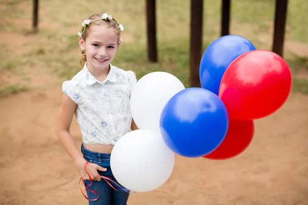 Mädchen spielt im Park mit Luftballons — Stockfoto