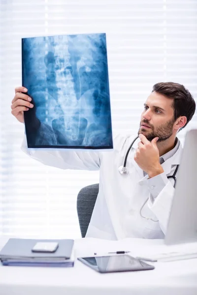 Muž lékař zkoumá x-ray — Stock fotografie