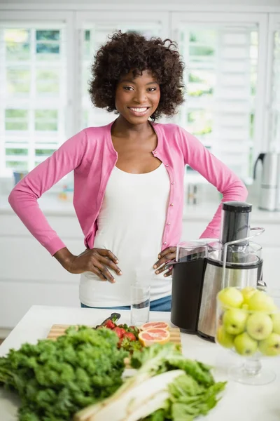 Lachende vrouw met hand op heup in keuken — Stockfoto