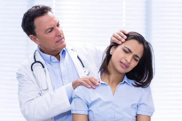 医師が女性患者の首を調べる — ストック写真