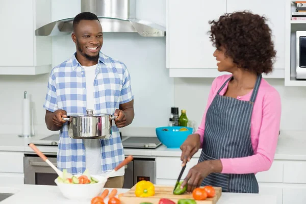 キッチンで野菜を刻んで笑顔のカップル — ストック写真