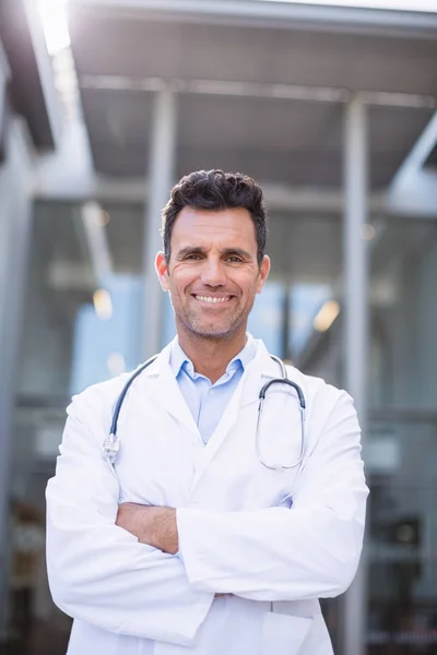 Портрет улыбающегося доктора, стоящего со скрещенными руками — стоковое фото