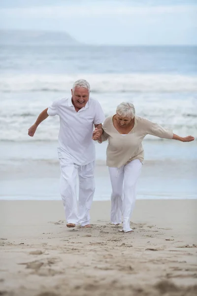 Senior para wspólna zabawa na plaży — Zdjęcie stockowe