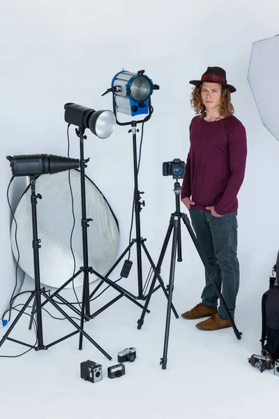 Fotógrafo com as mãos no bolso em pé no estúdio de fotografia — Fotografia de Stock