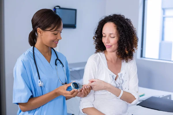 Lekarza przeprowadzającego badanie cukru we krwi w ciąży womans — Zdjęcie stockowe