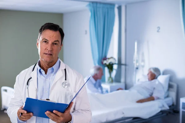 Portrait of male doctor holding a medical report — Stok Foto