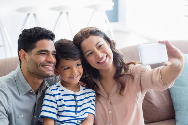 Ouders en zoon nemen van een selfie vanaf mobiele telefoon in woonkamer — Stockfoto