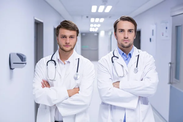 Retrato de médicos de pé com os braços cruzados no corredor — Fotografia de Stock