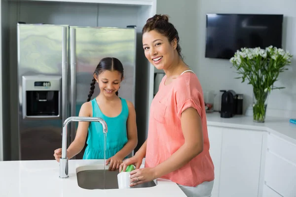 Matka pomáhá její dcera v čištění nádoby — Stock fotografie