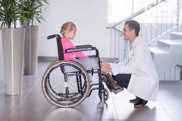 Médico sorridente falando com menina incapacitante — Fotografia de Stock