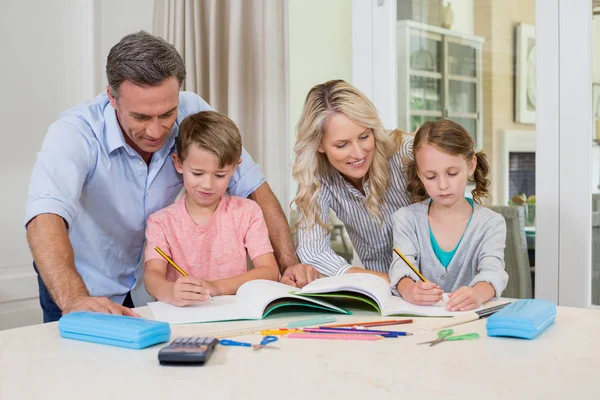 Föräldrar hjälpa barn göra läxor — Stockfoto