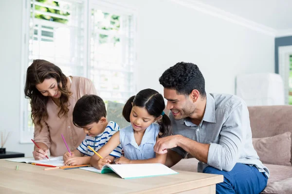 Padres ayudando a sus hijos a hacer la tarea — Foto de Stock