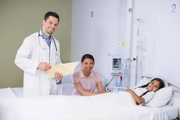 Retrato de médico y niña en cama de hospital — Foto de Stock