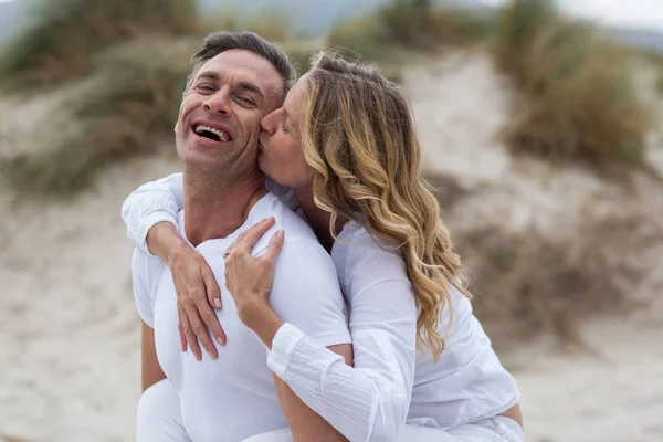 Reifer Mann gibt Huckepack-Fahrt zu Frau am Strand — Stockfoto