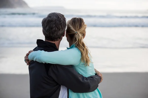 Зрелая пара обнимает друг друга на пляже — стоковое фото