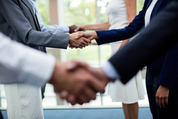 La mitad de la sección de ejecutivos de negocios estrechando la mano entre sí —  Fotos de Stock