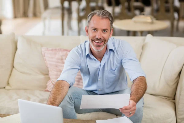 Hombre feliz sosteniendo una cuenta en la sala de estar — Foto de Stock