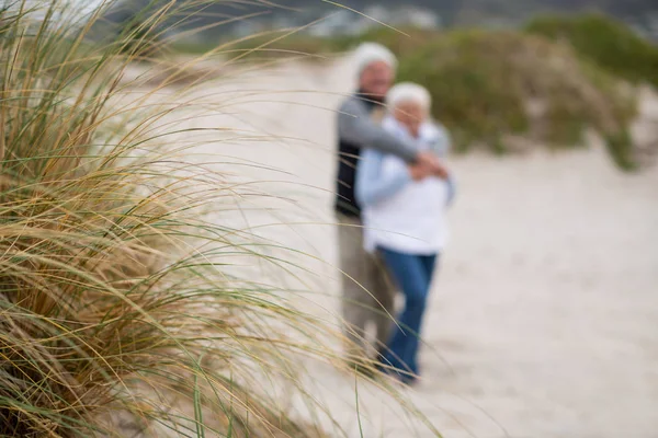 Seniorenpaar steht zusammen am Strand — Stockfoto