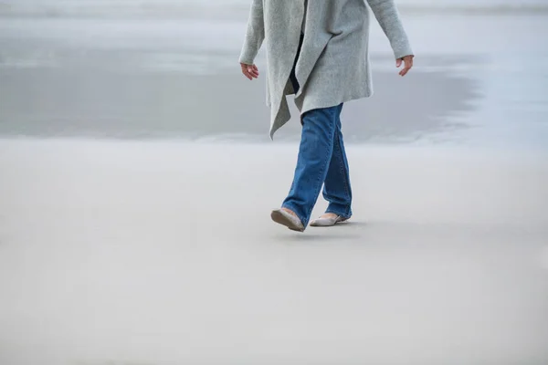 海の近くを歩く年配の女性 — ストック写真