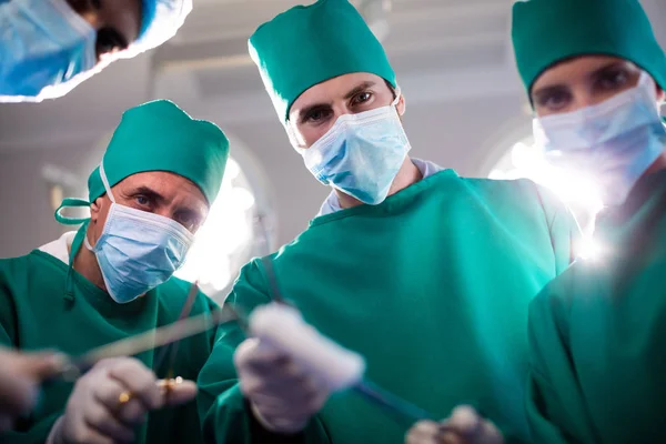 Портрет медичної команди, що тримає медичне обладнання в операційній кімнаті — стокове фото