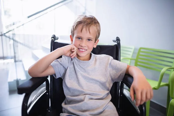 Retrato de menino sorridente paciente sentado em uma cadeira de rodas — Fotografia de Stock