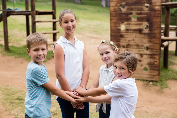 Дети формируют стопку рук в парке — стоковое фото