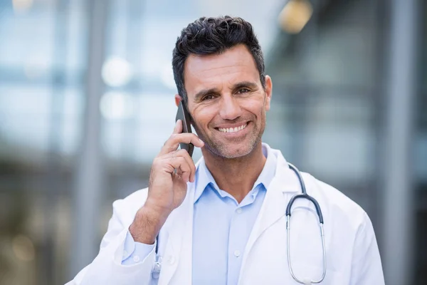 Porträtt av leende läkare talar på mobiltelefon — Stockfoto