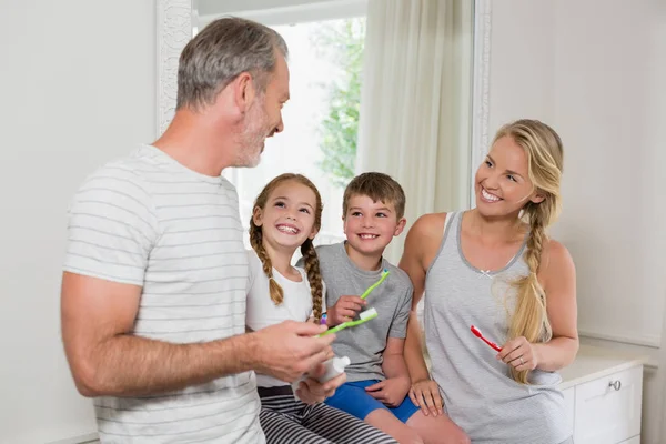 Föräldrar och barn interagerar med varandra när du borstar tänderna i badrum — Stockfoto