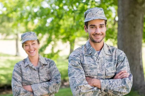 Porträt eines Militärpaares, das mit verschränkten Armen im Park steht — Stockfoto