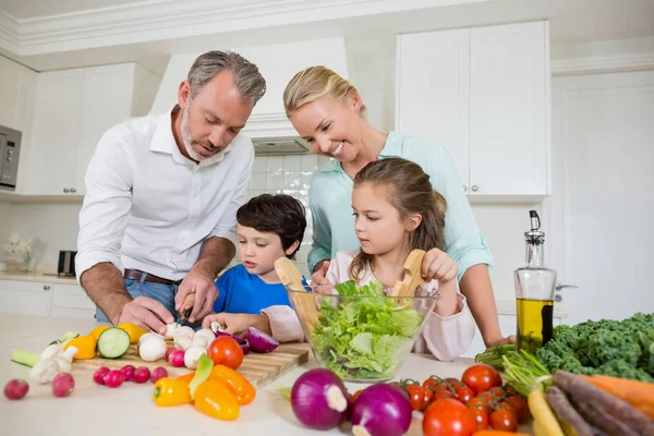 Föräldrarna hjälpa barnen att hugga vegetabiliska — Stockfoto