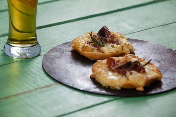 Deliciosa pizza servida em bandeja de pizza com um copo de cerveja — Fotografia de Stock