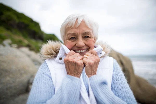 Retrato de una mujer mayor de pie en la playa —  Fotos de Stock