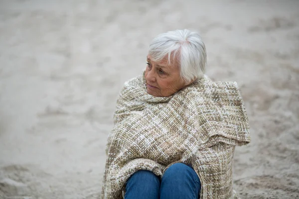 Starší žena v šátku na pláži — Stock fotografie