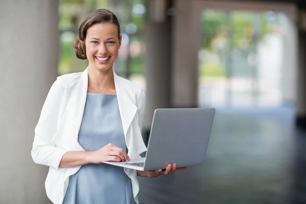 Glada affärskvinna hålla laptop i conference centre — Stockfoto